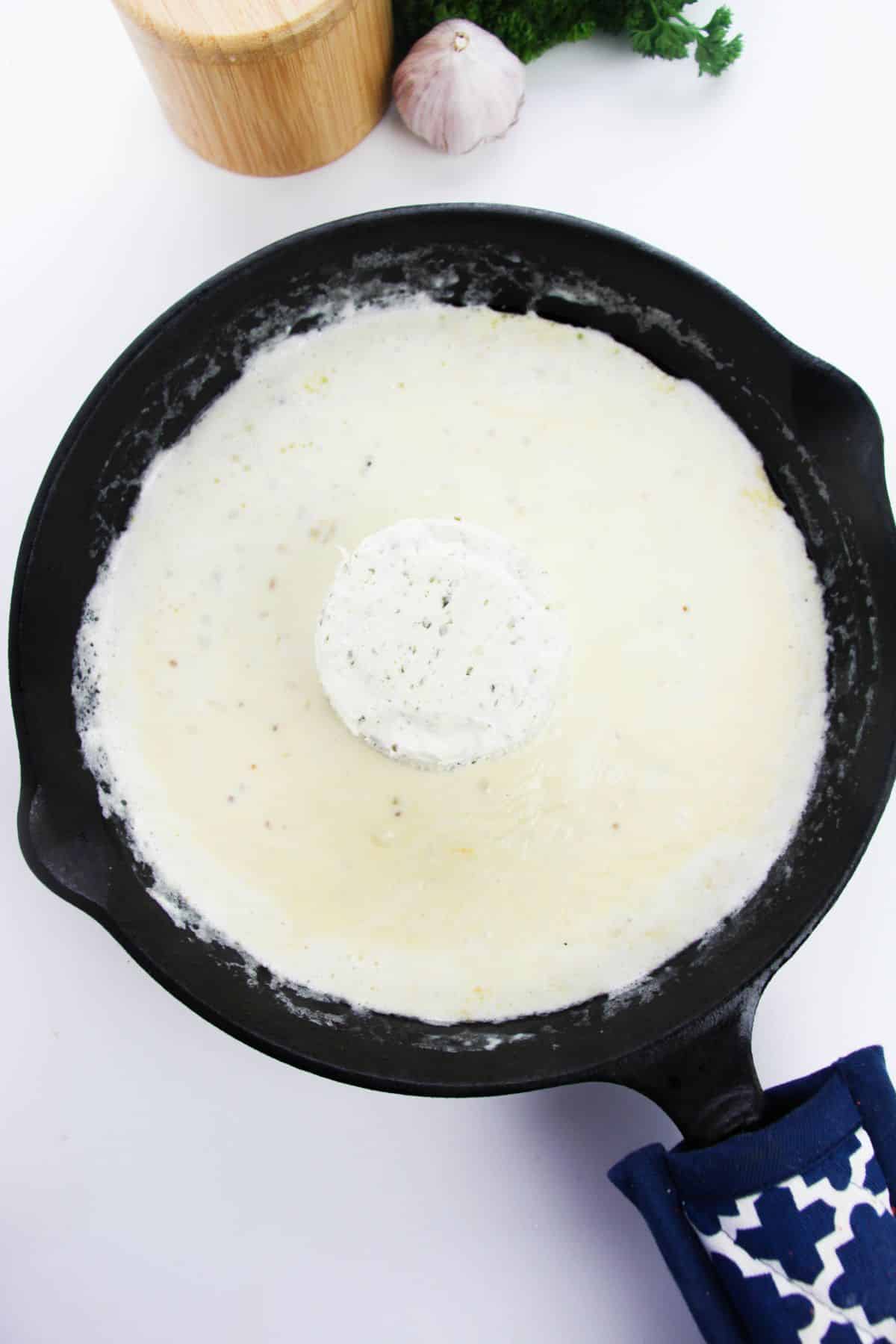 Boursin cheese is stirred into the skillet.