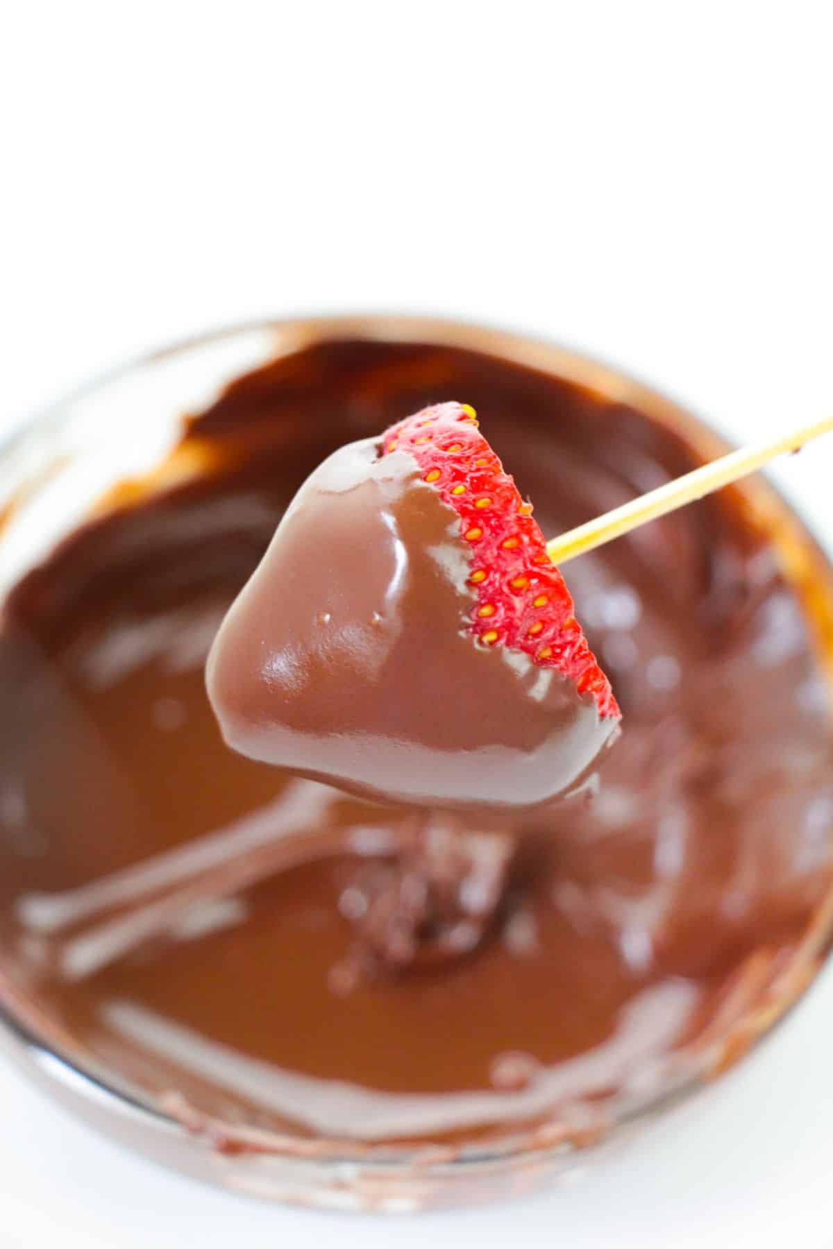 The strawberry is dipped in melted chocolate.