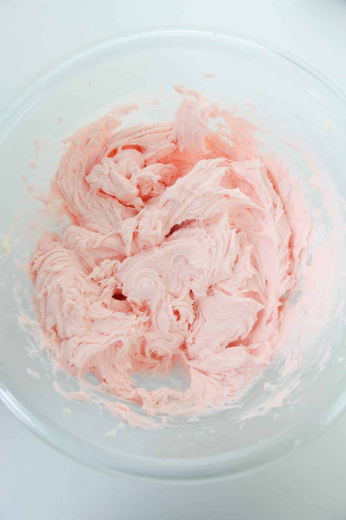 Milk and strawberry extract are added to the frosting mixture.