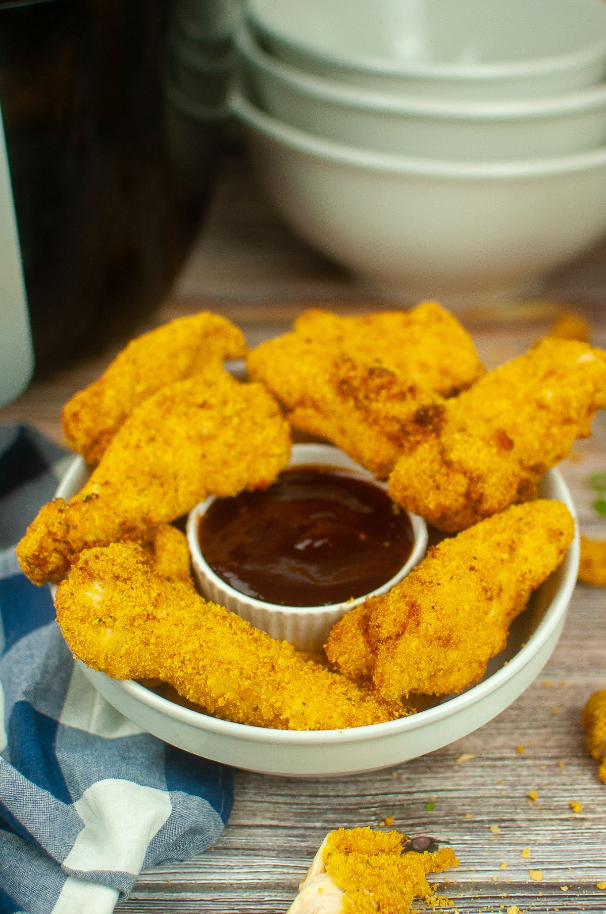 Easy Air Fryer Chicken Tenderloins (Shake and Bake) on a serving plate with dipping sauce in the middle.