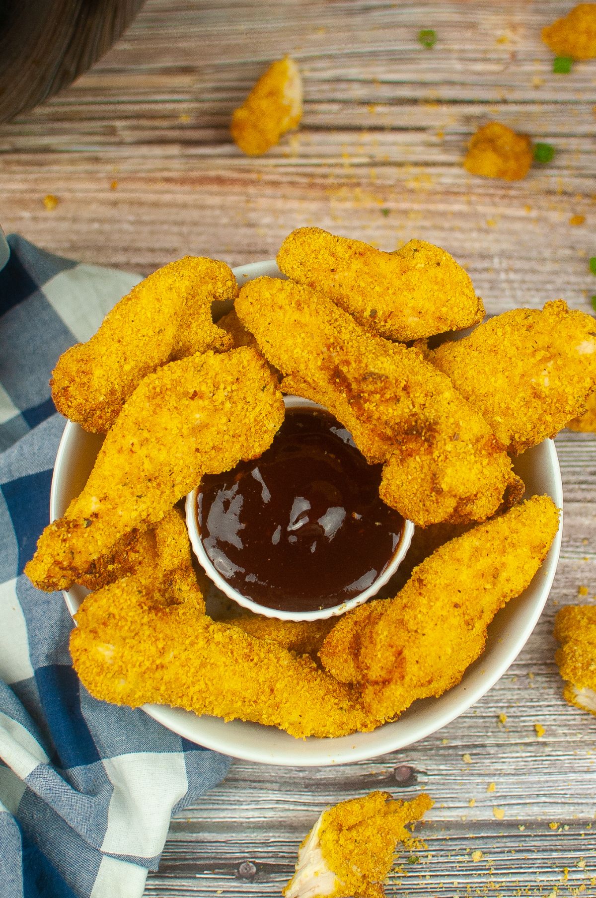 Air Fryer Chicken Tenderloins on a serving plate with dipping sauce in the middle.