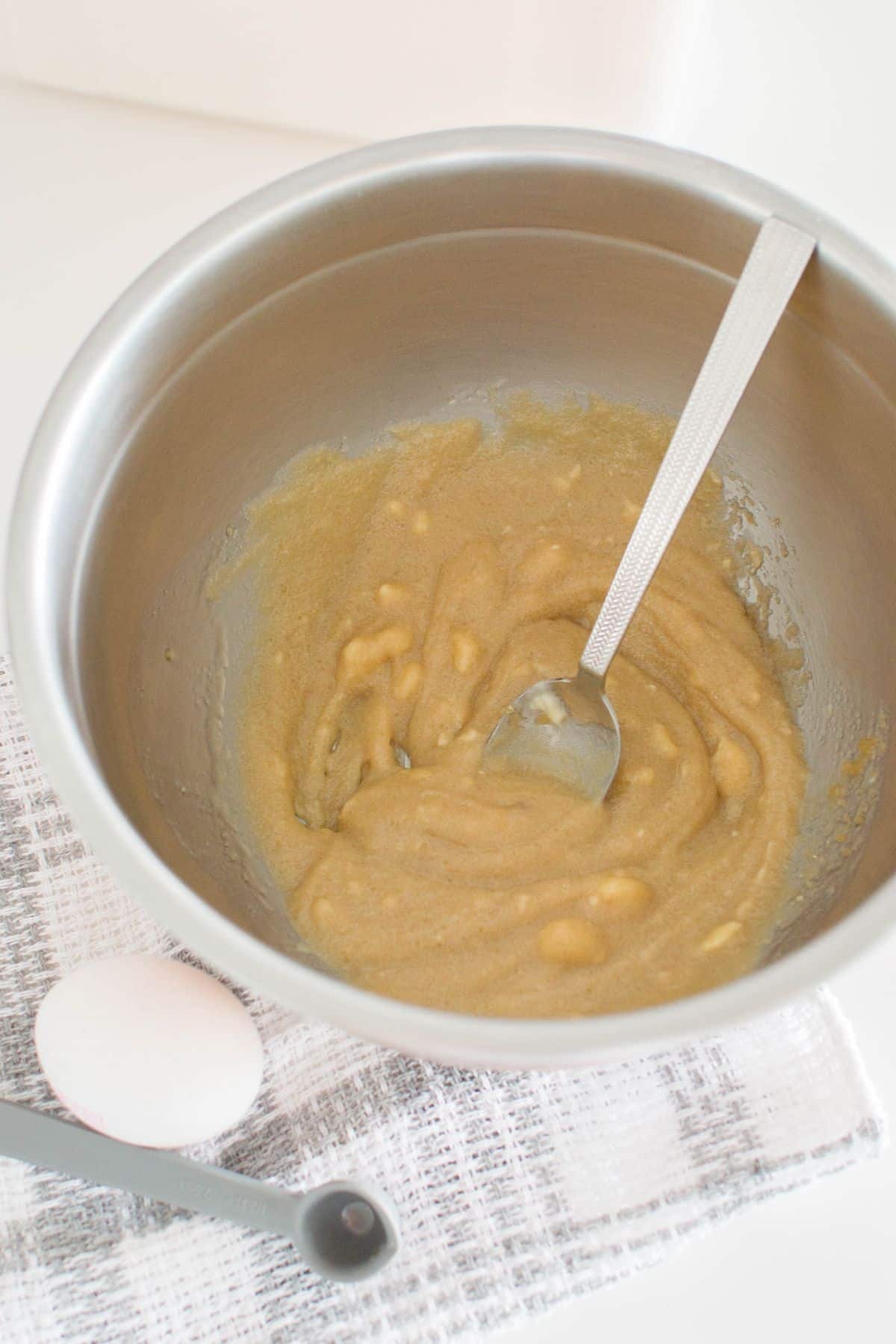 Butter and brown sugar were beaten together in a large bowl with spoon.