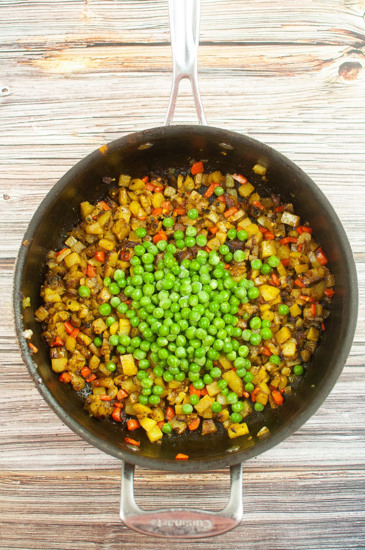 The peas and seasonings are added to the large skillet.