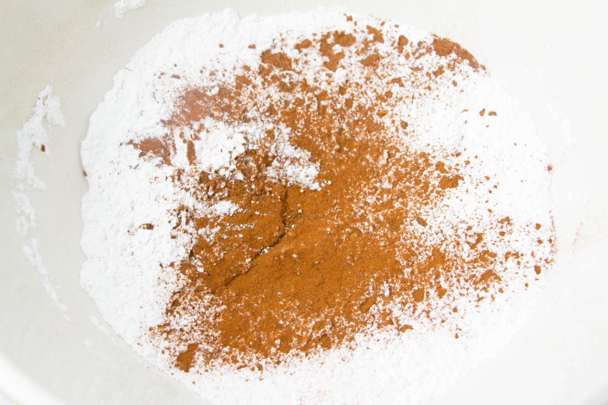 flour, white sugar, baking powder, salt, cinnamon, nutmeg, and ginger in a mixing bowl.