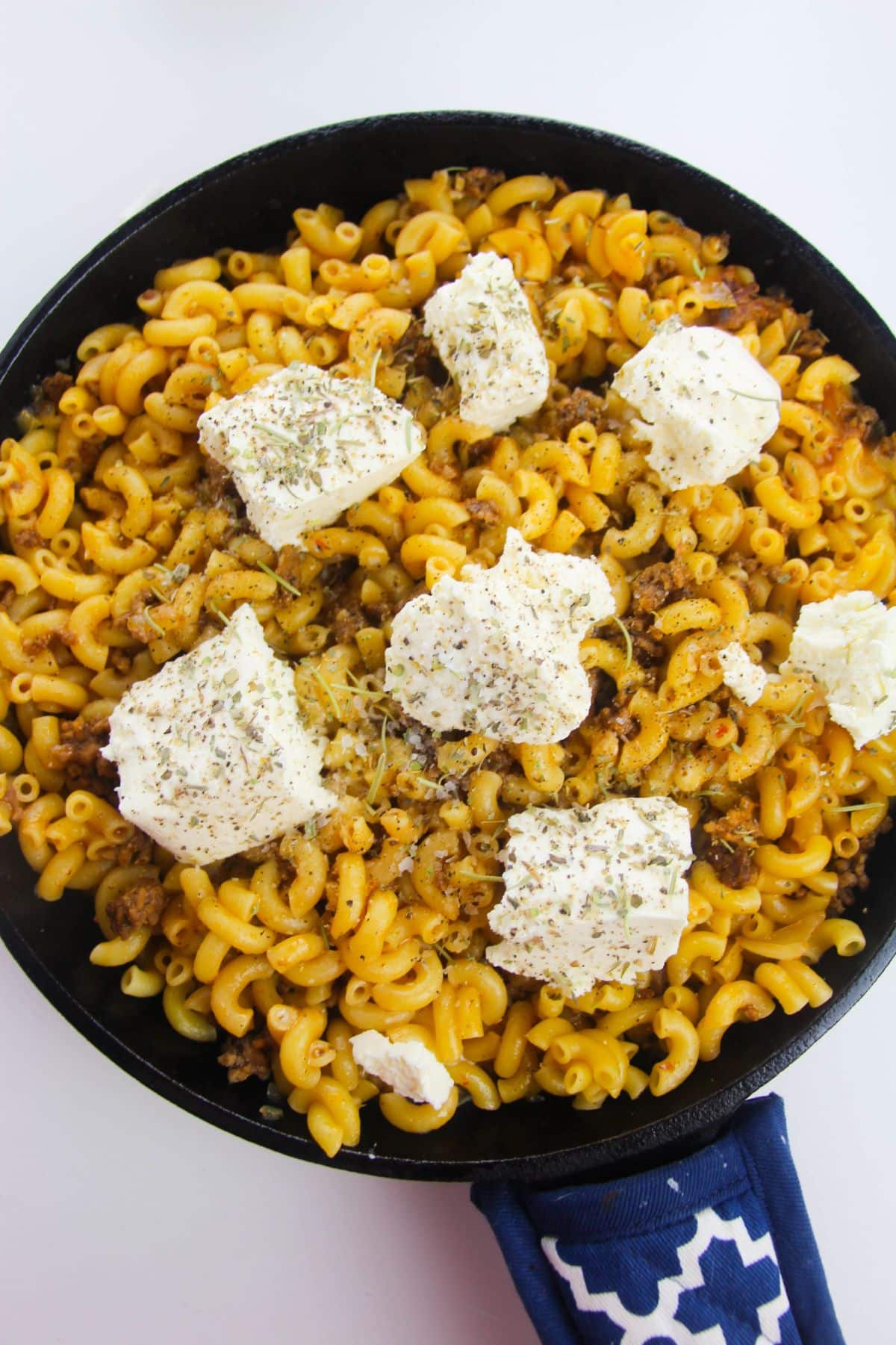 Cream cheese, milk, Italian seasoning, salt and pepper are added to the pasta in a large skillet.