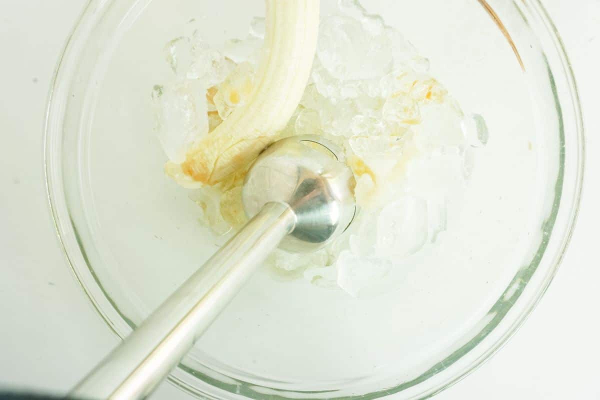 using an immersion blender, ingredients are blended in a glass bowl.