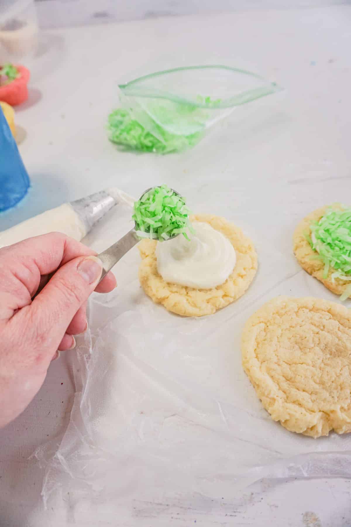 a tablespoon of the green coconut are being placed into the cookies.