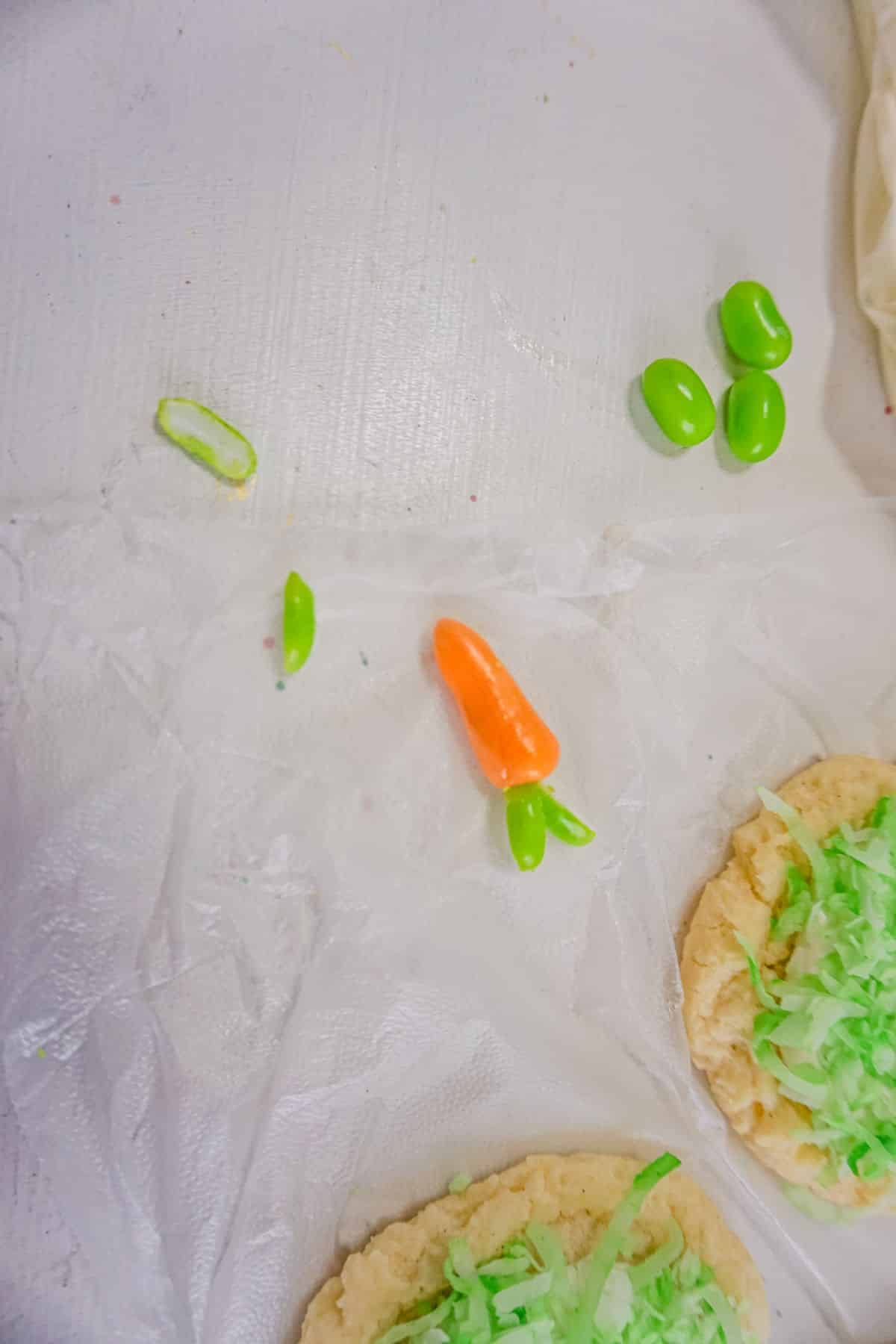 orange Starburst shaped into carrots with green jelly beans cut into portions.