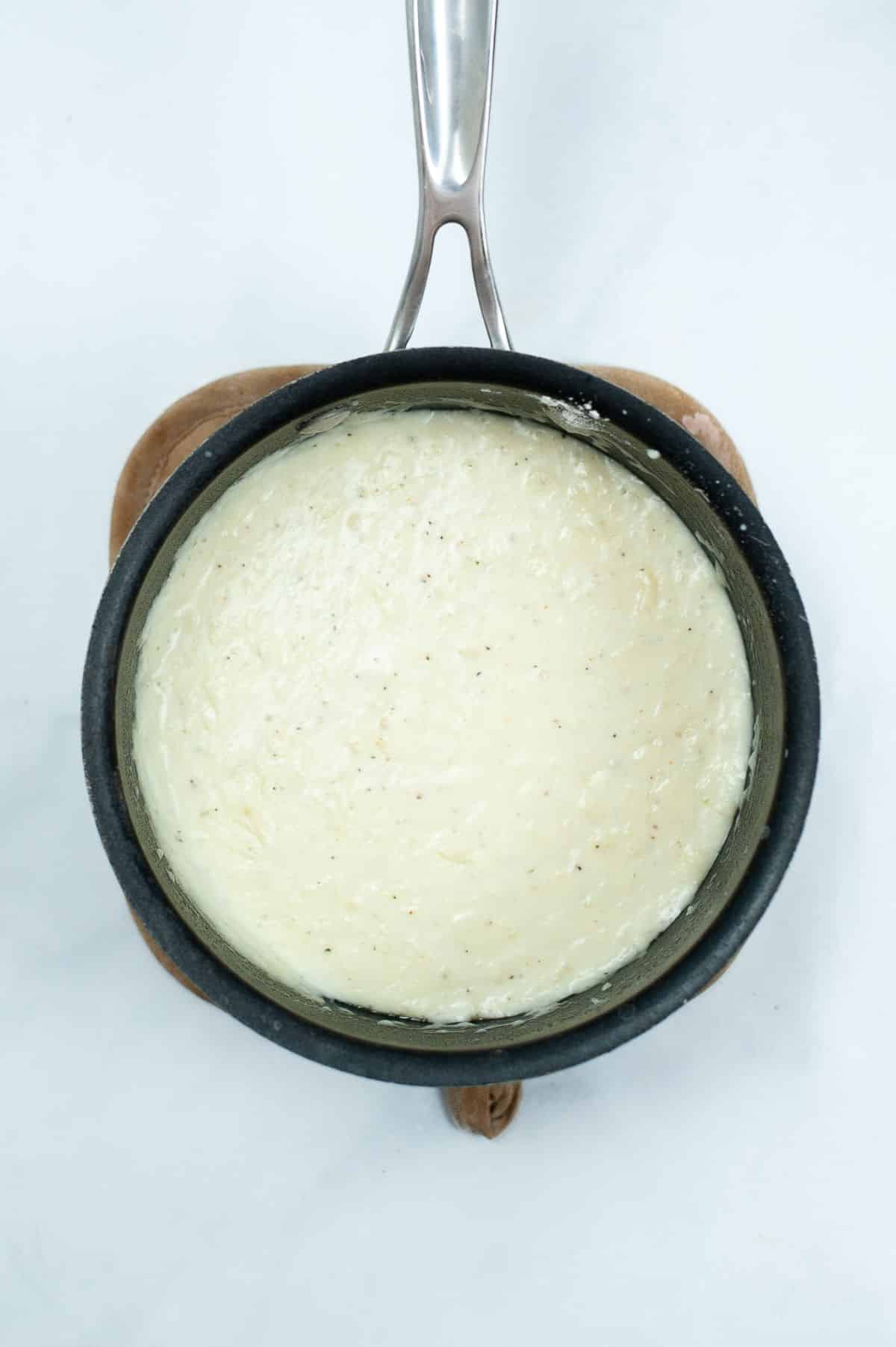 overhead view of white gravy in a pan