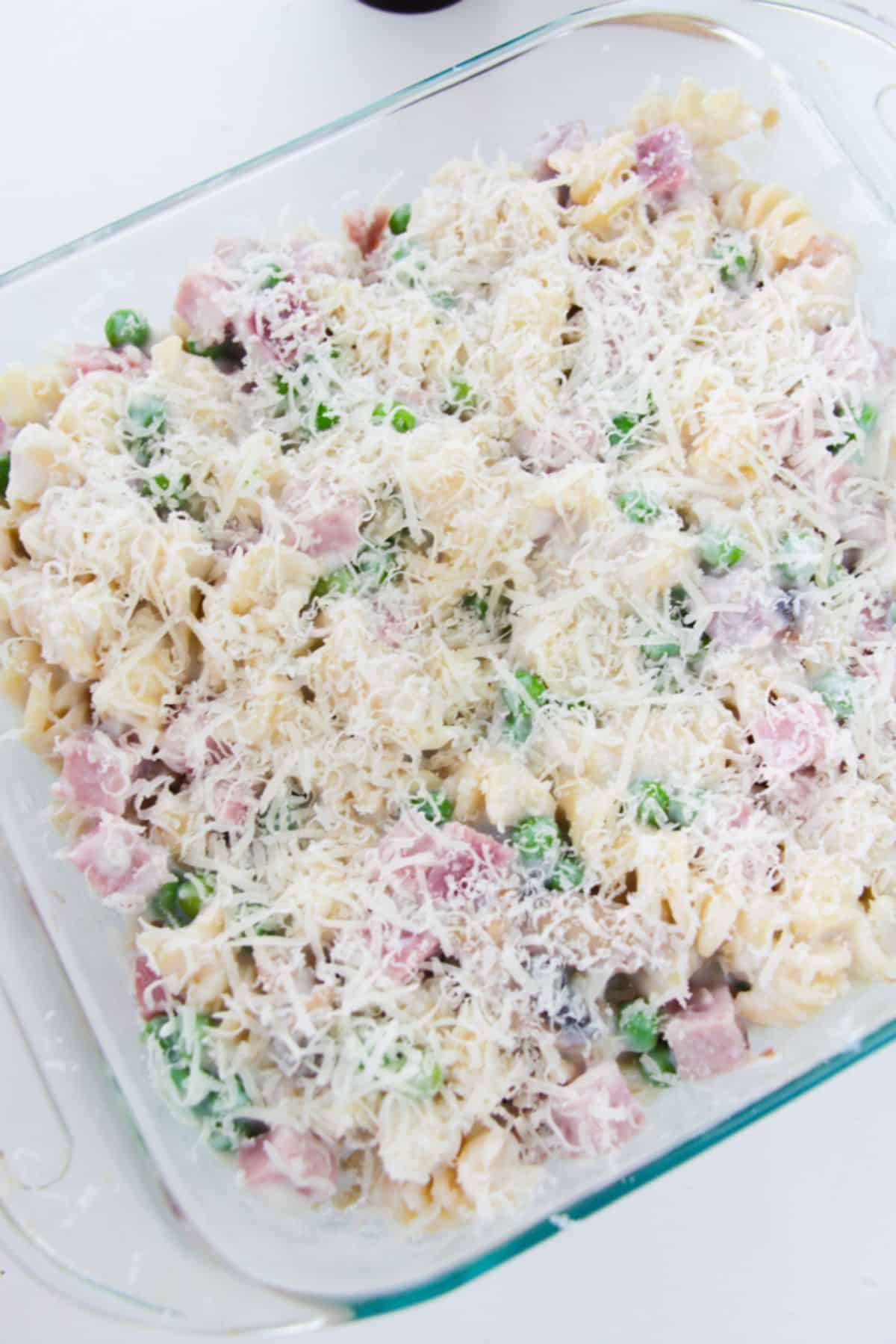 Pasta mixture in a casserole dish with parmesan cheese.