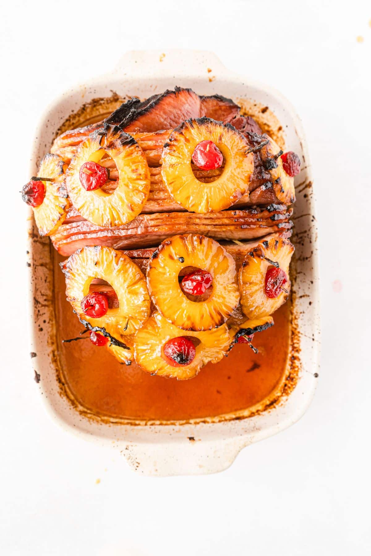 Baked ham with cherries and pineapples in a baking dish.