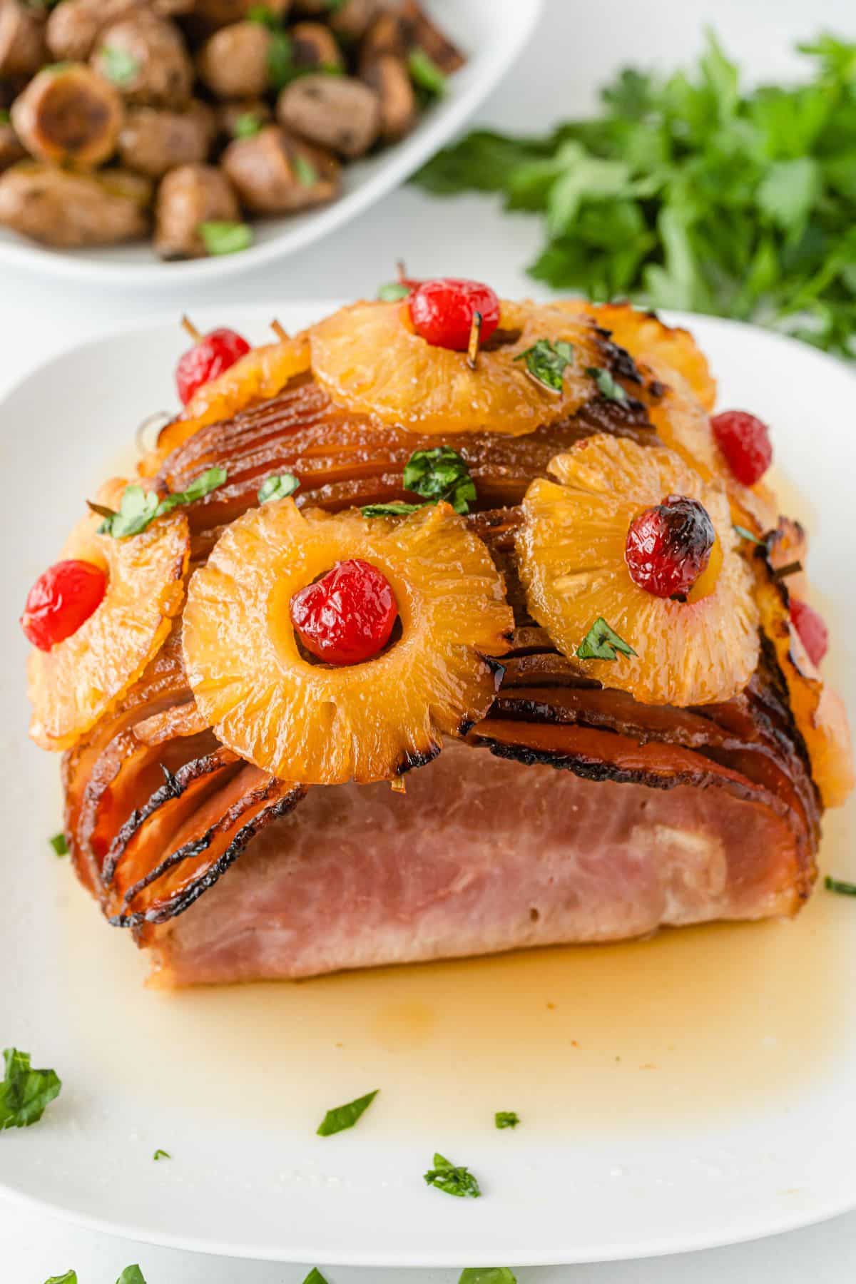 Ham with Pineapple and Cherries on a serving plate, garnished with parsley.