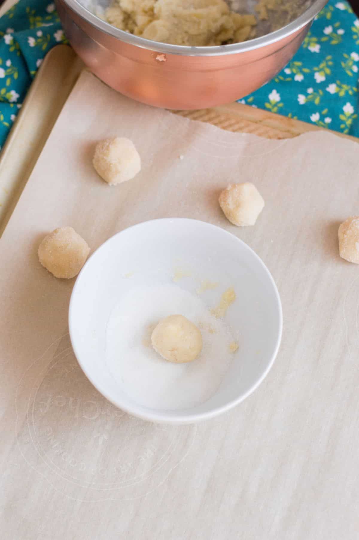 dough balls are rolled in granulated sugar.