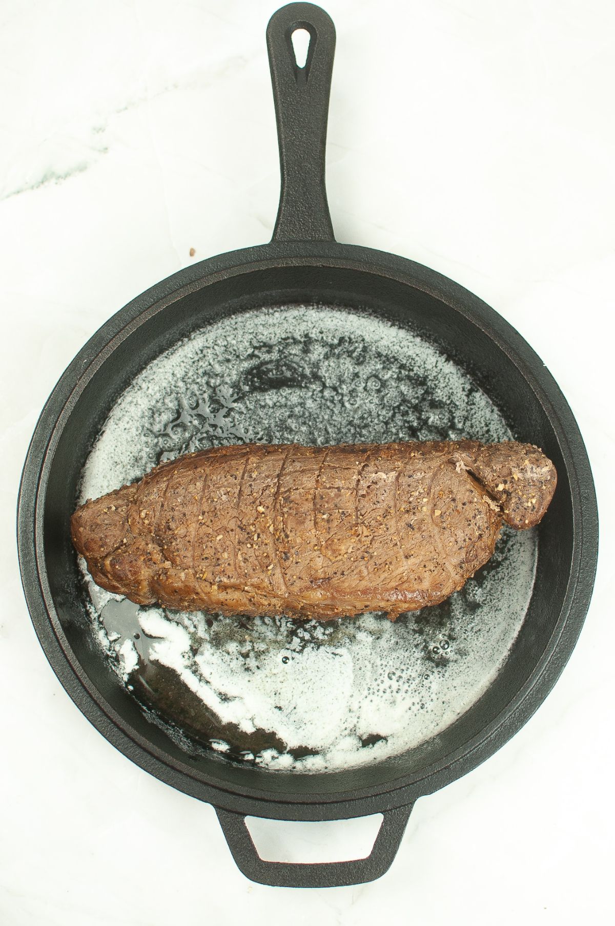 beef loin in a skillet with butter.