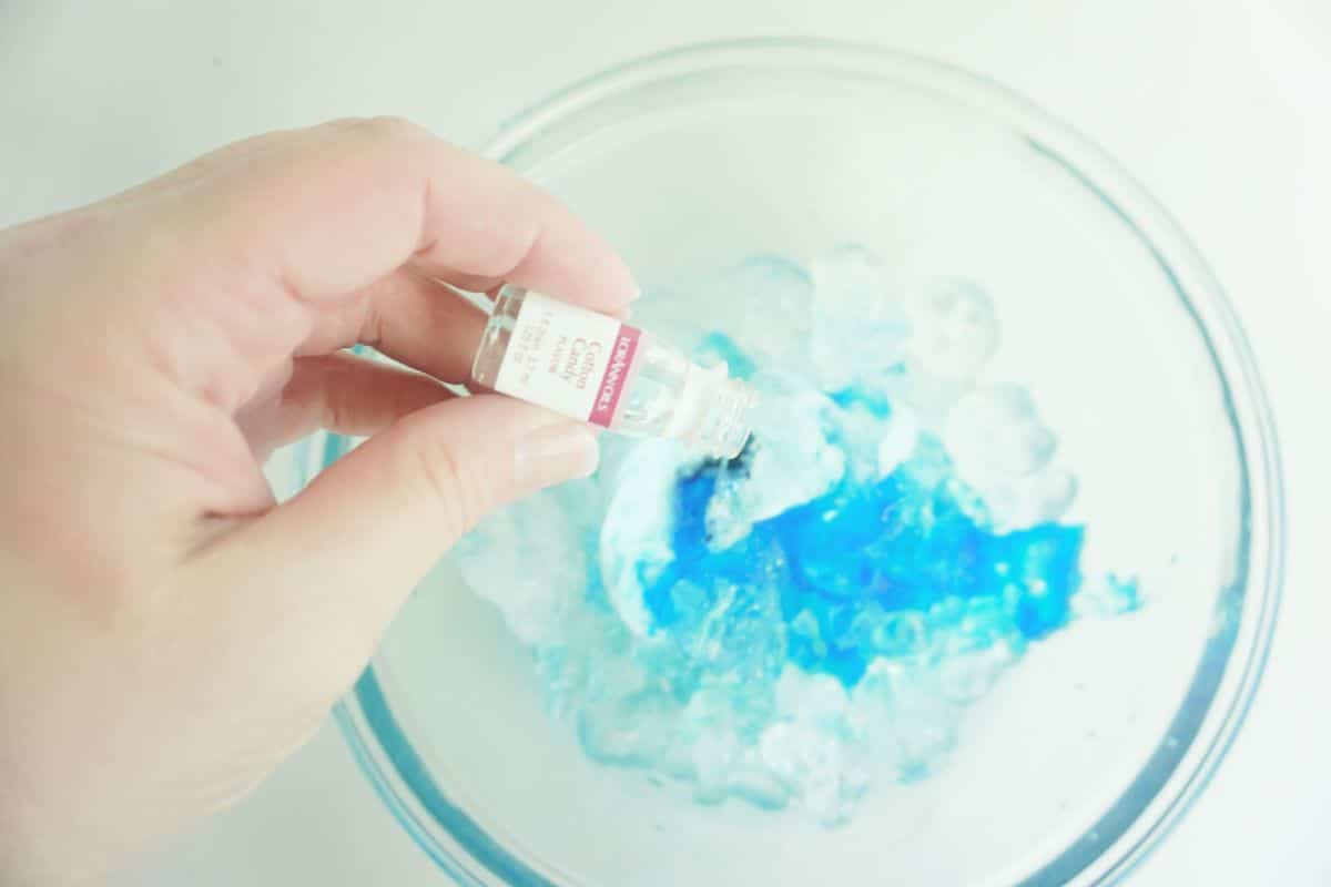 Ice, cotton candy, food coloring, and flavoring oil are added to the glass bowl.