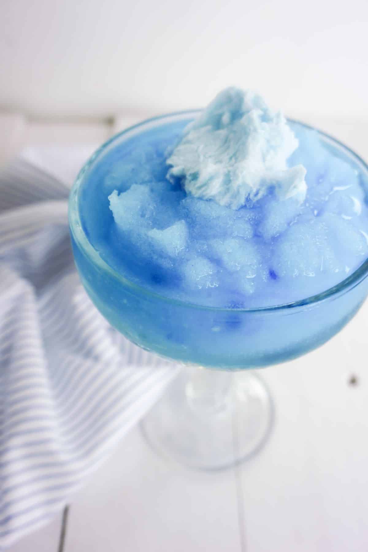 Cotton Candy Margarita in a serving glass, garnished with cotton candy on top.