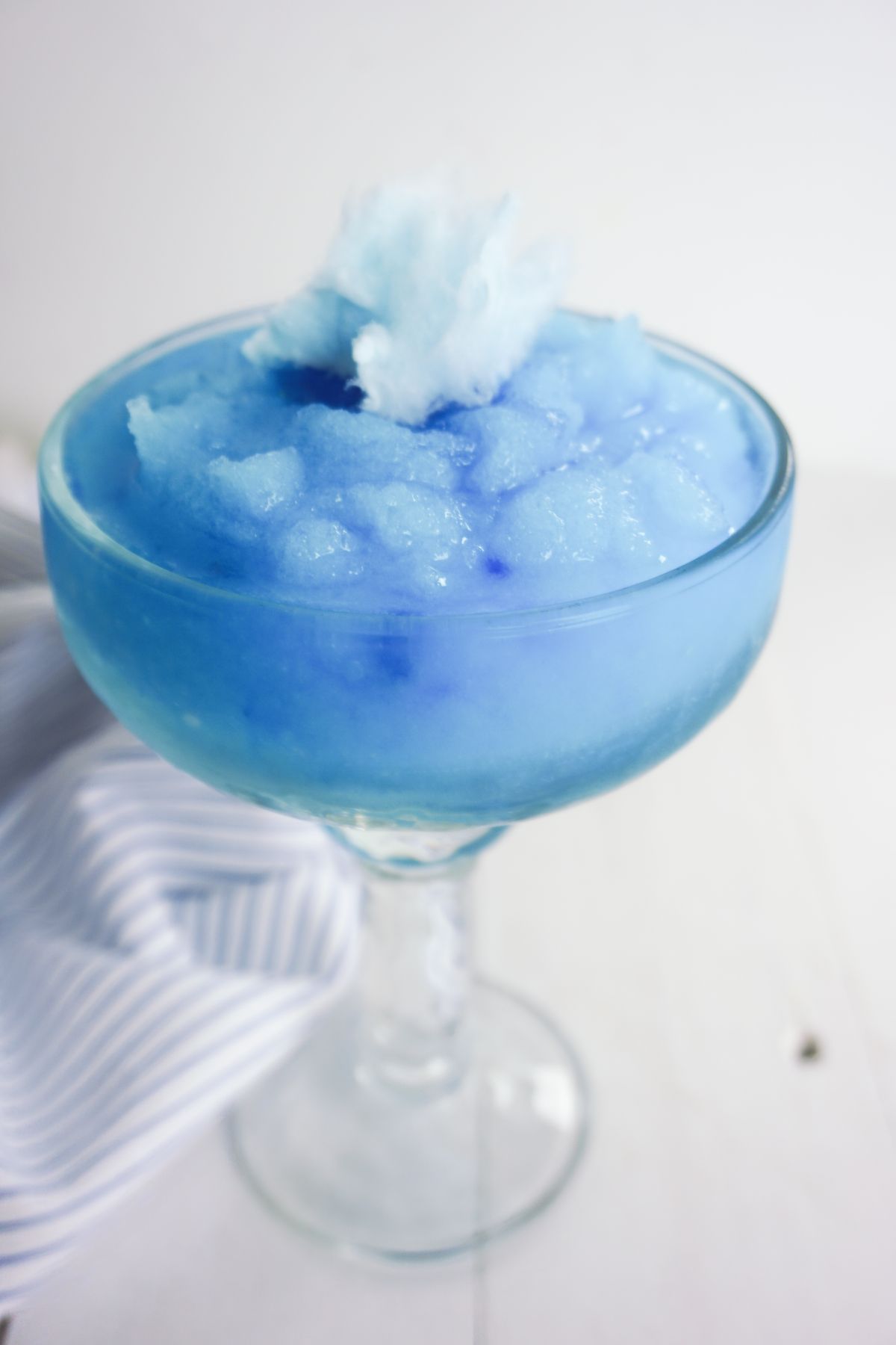 Cotton Candy Margarita in a serving glass, garnished with cotton candy.