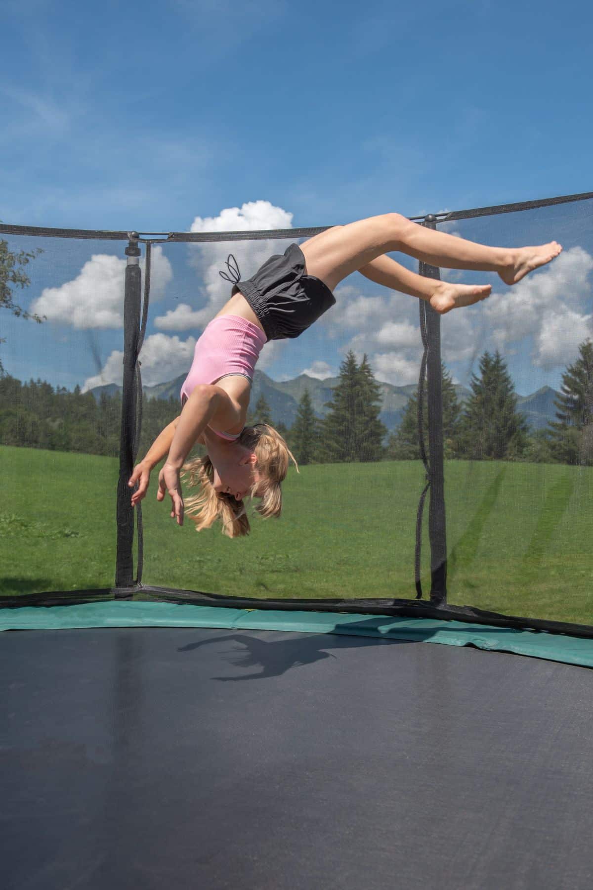 a girl doing a backflip on a trampoline.