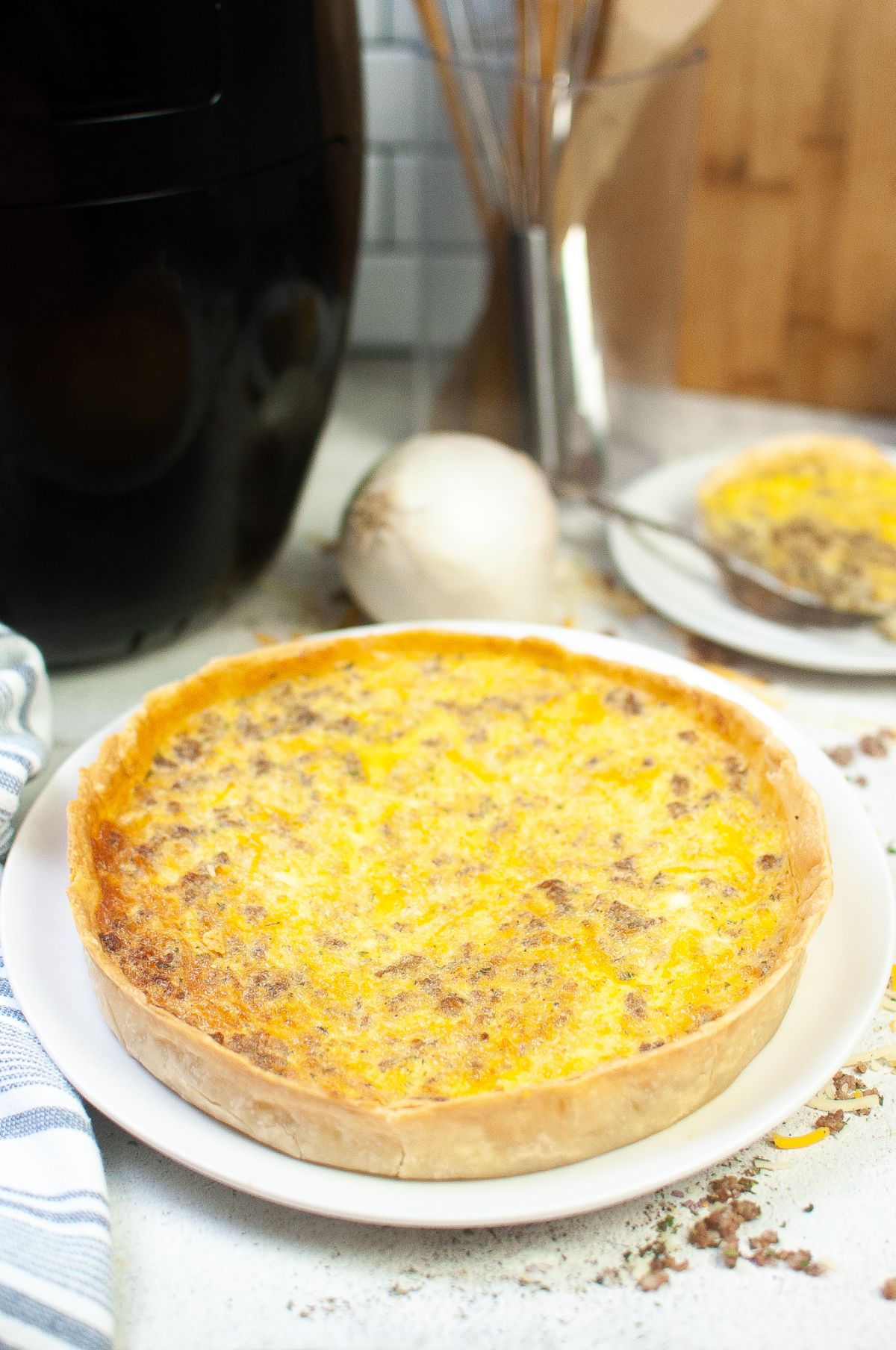 Air Fryer Quiche with Sausage on a white serving plate.