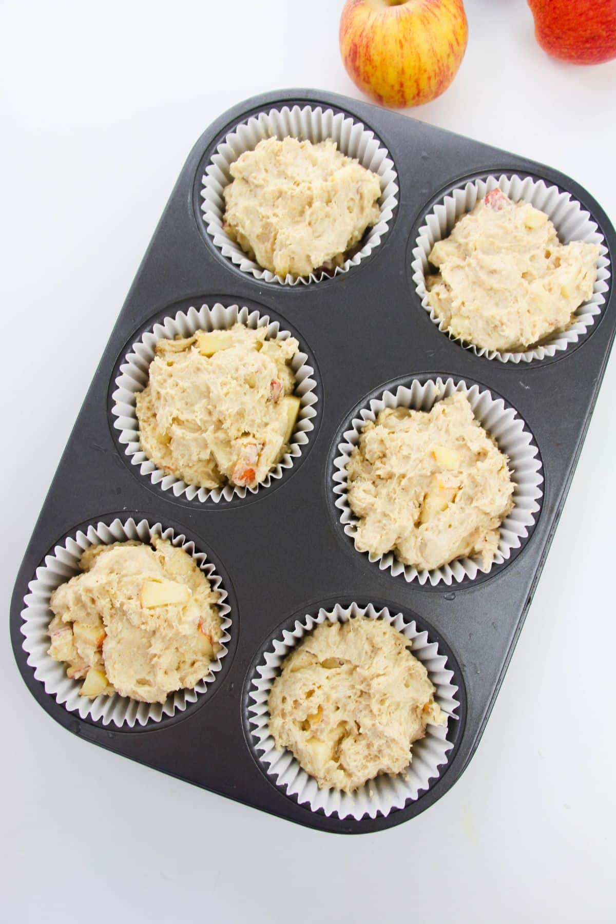 Muffin batter in a muffin tin with paper liners.