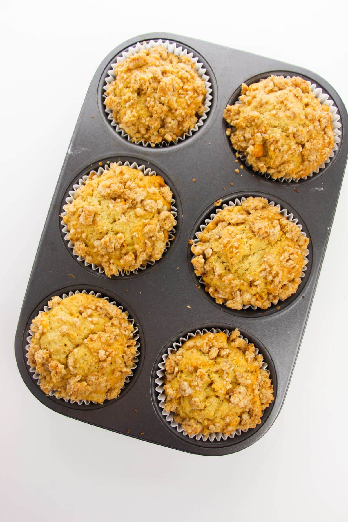 Apple Crumble Muffins in a muffin tin.