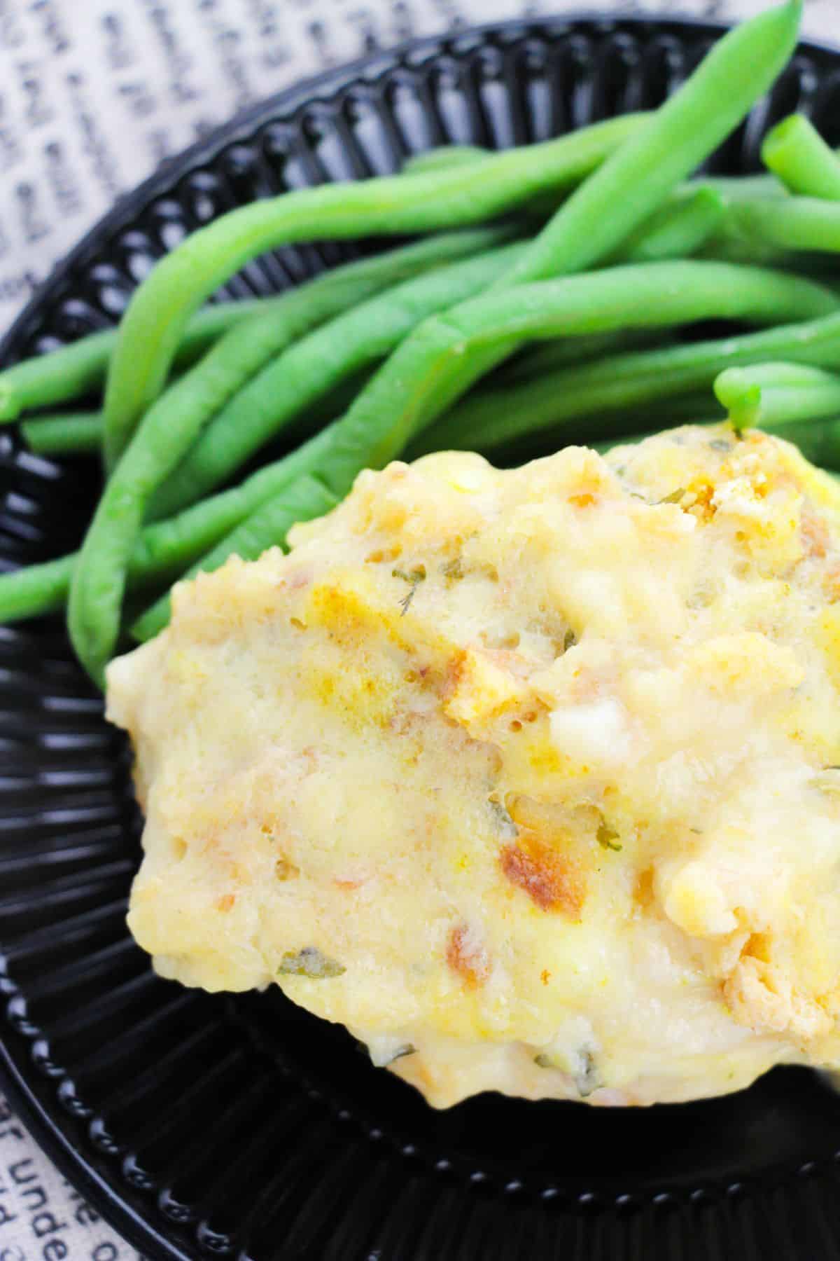 Swiss Chicken Casserole on a serving plate with green beans on the side.
