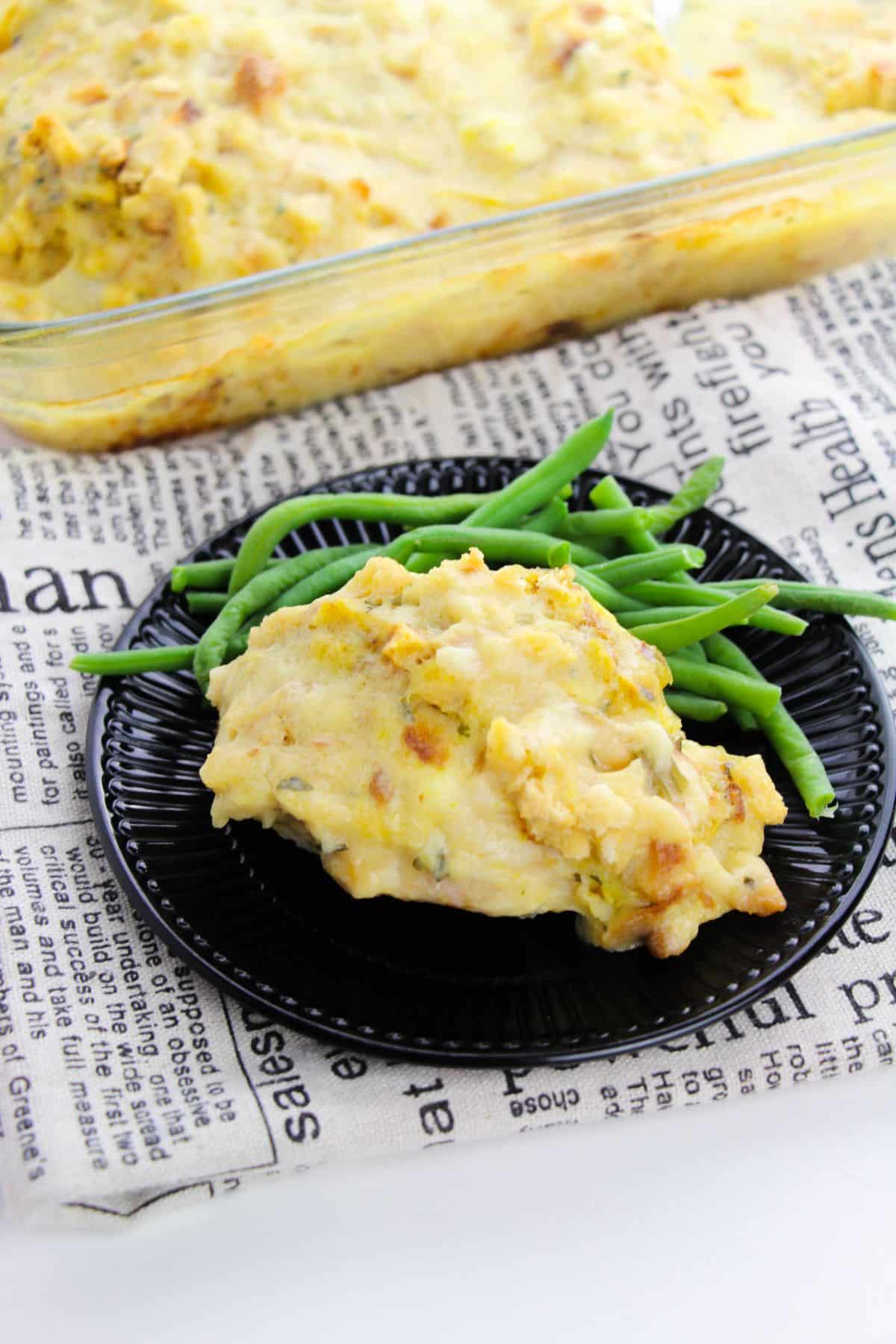 Swiss Chicken Casserole on a serving plate with green beans on the side.