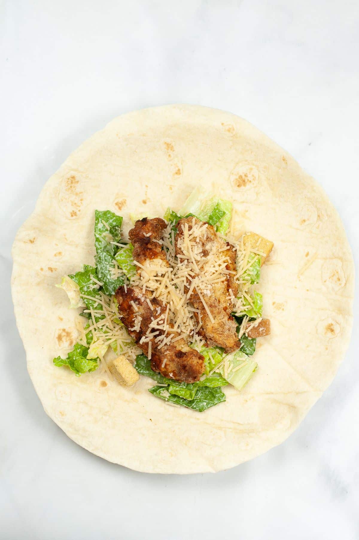 Tortilla with salad mixture and chicken.