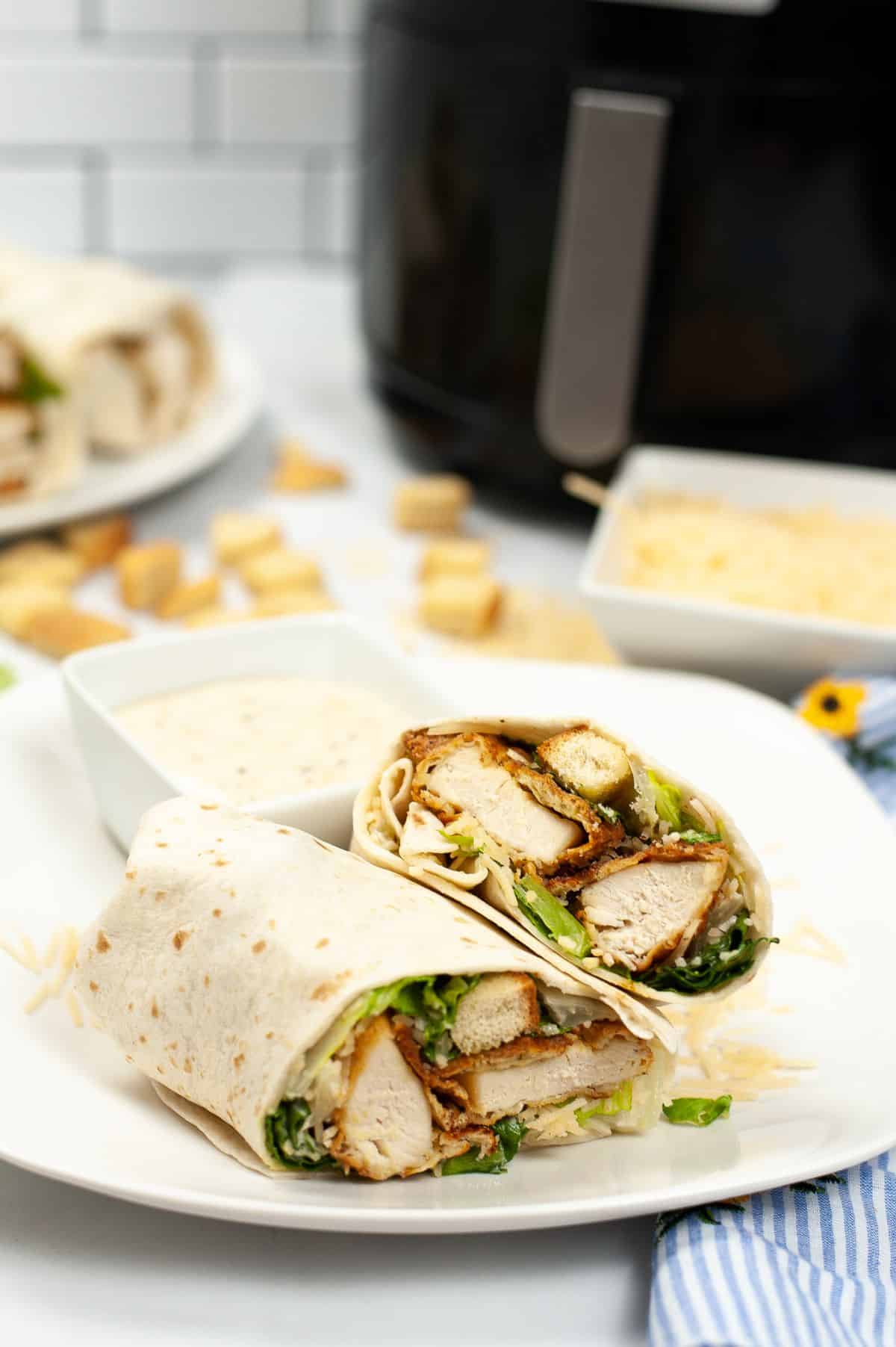 Fried Chicken Wrap on a serving plate with Caesar dressing and Air Fryer on the side.