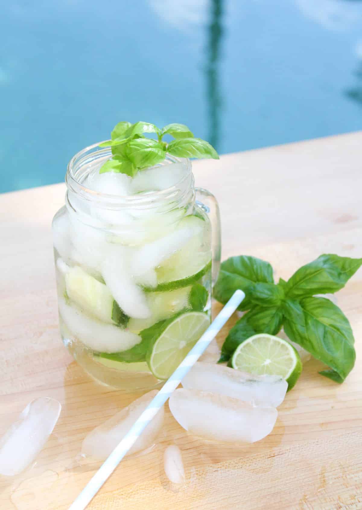 Cucumber Lime Vodka Cocktail in a serving glass, garnished with basil leaves.