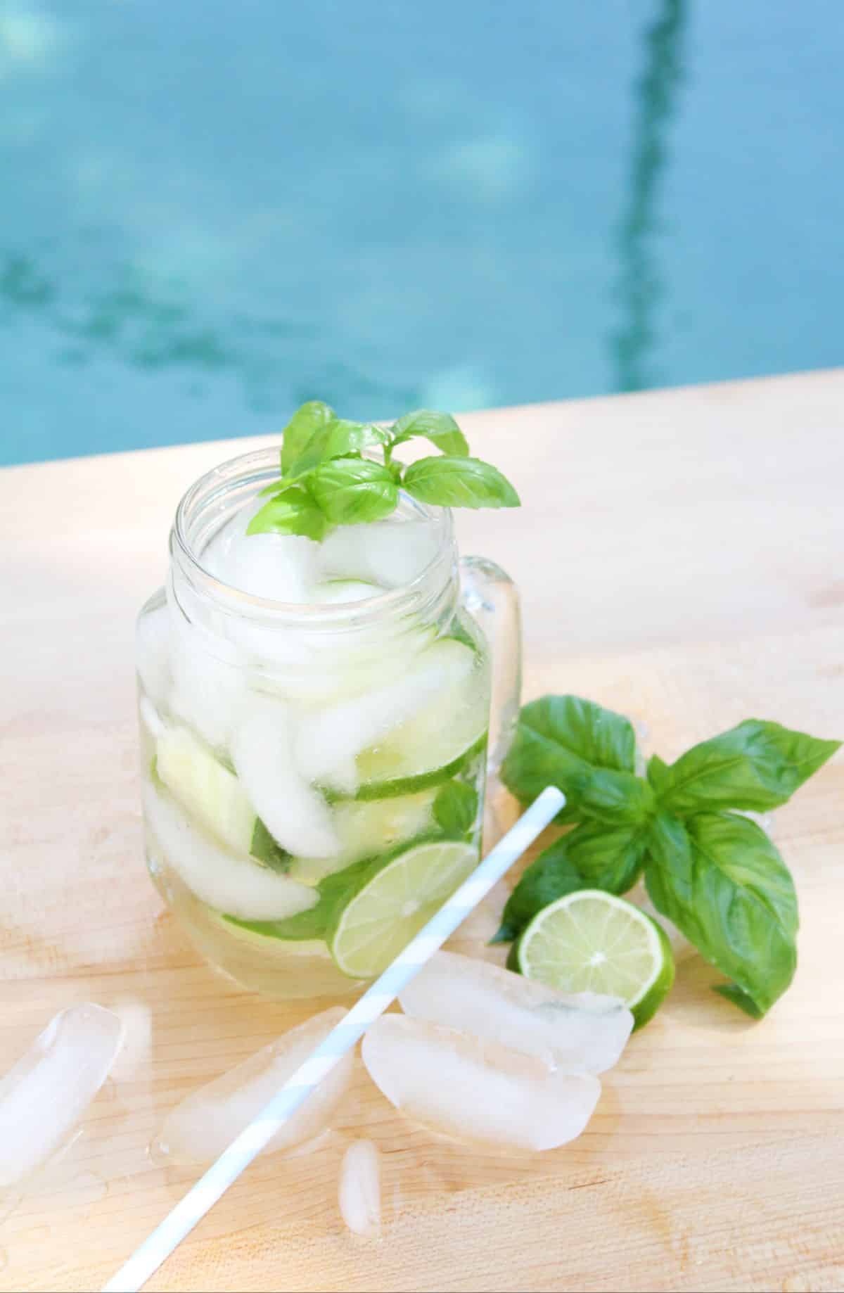 Cucumber Lime Vodka Cocktail in a serving glass, garnished with basil leaves.