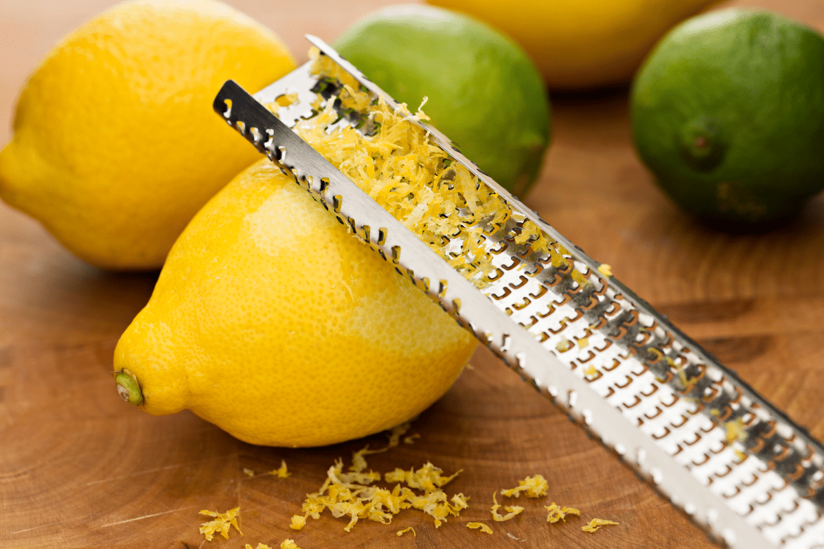 A close up shot of lemon with zester and limes.