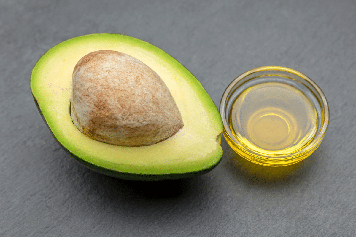 Avocado oil in a small bowl with avocado on the side.