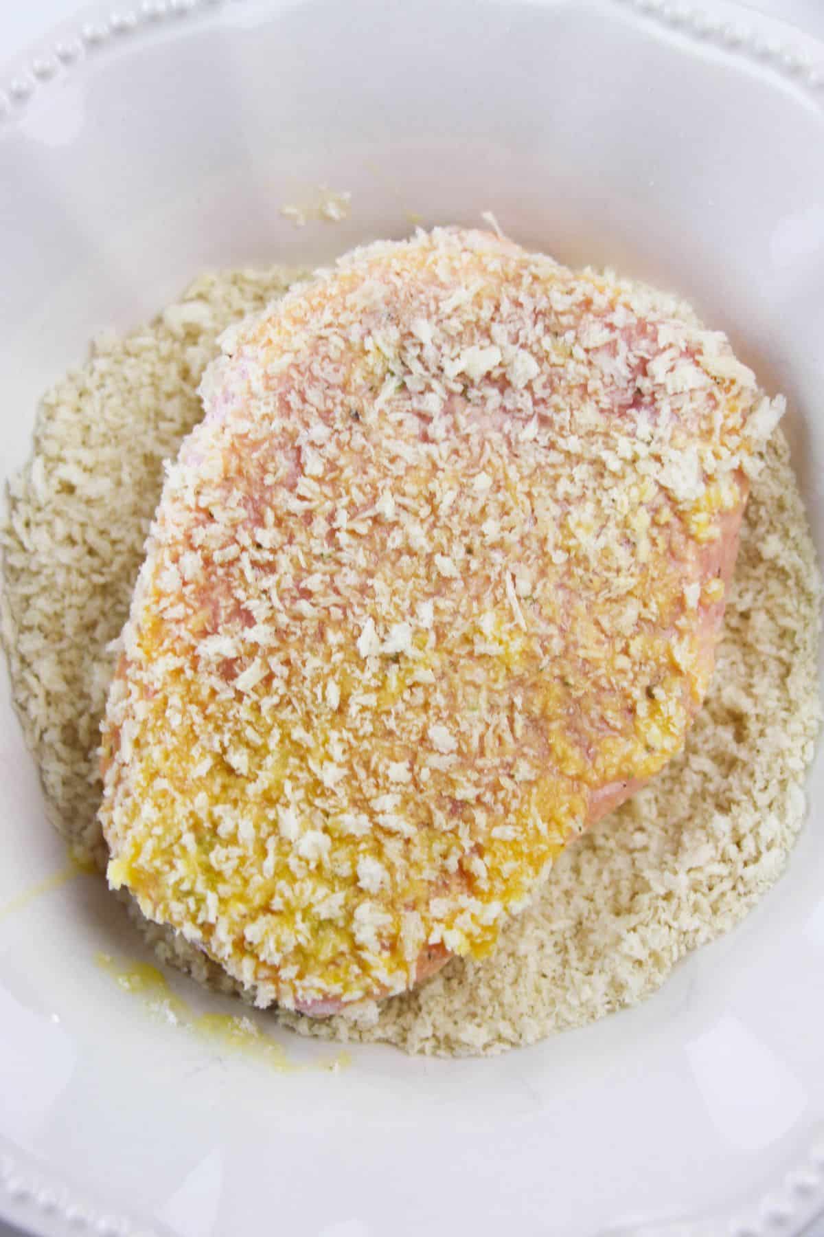 A pork chop coated with flour mixture, egg and bread crumbs.