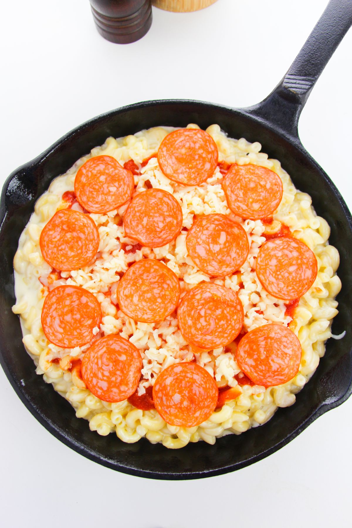 Macaroni, cheese mixture and pepperoni in a skillet.