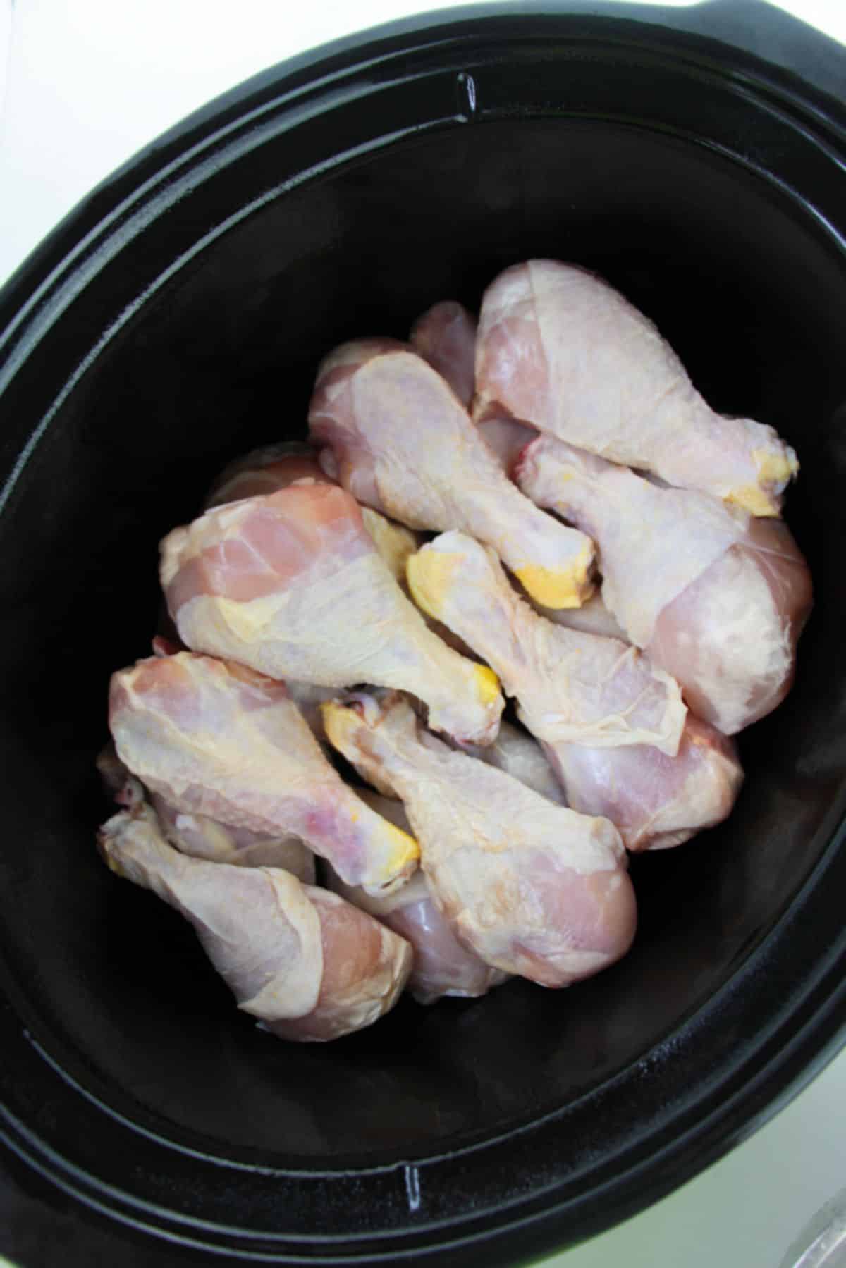 Chicken legs layered in slow cooker.