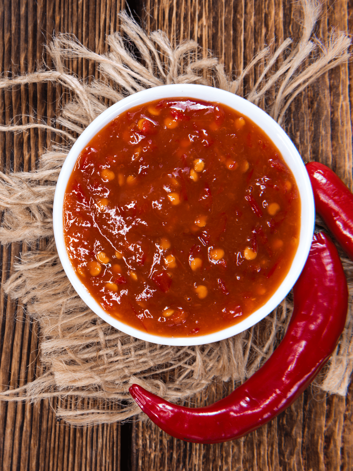 Chili sauce in a bowl on a wooden table.