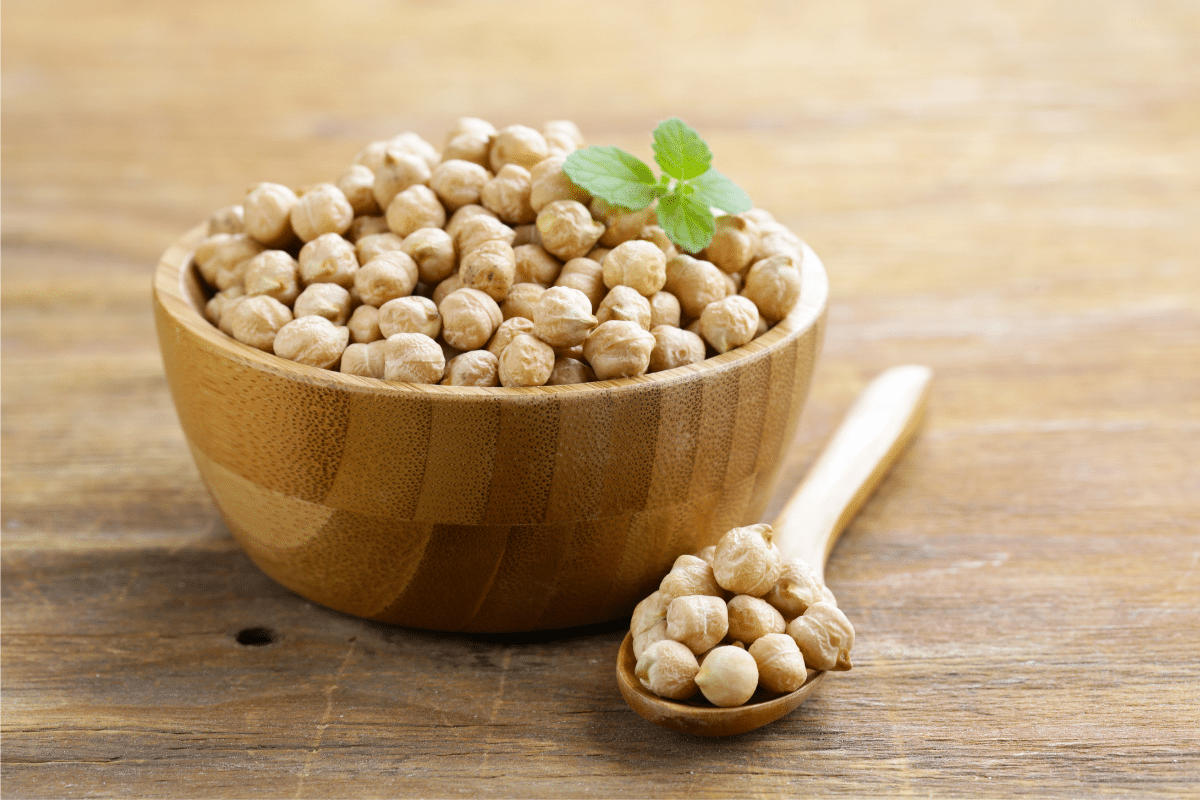 Chickpeas, a healthy substitute for quinoa, in a wooden bowl on a wooden table.