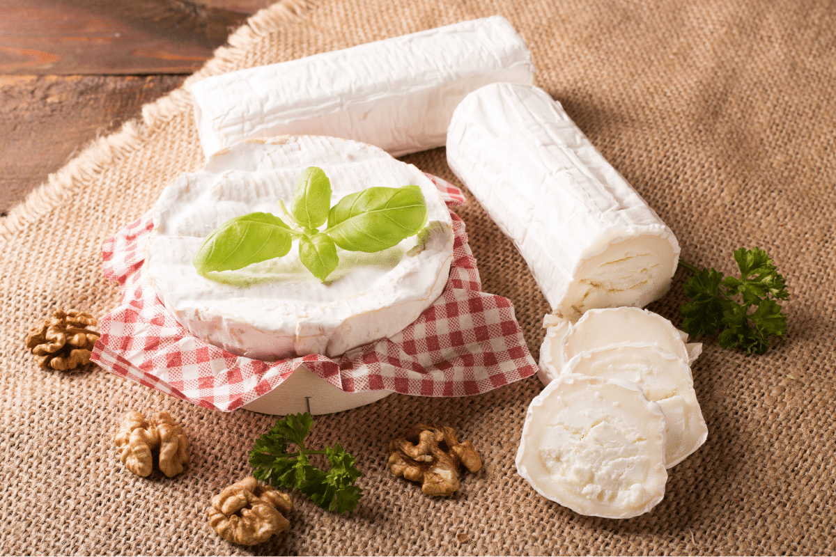 Goat cheese with walnuts on a wooden table.