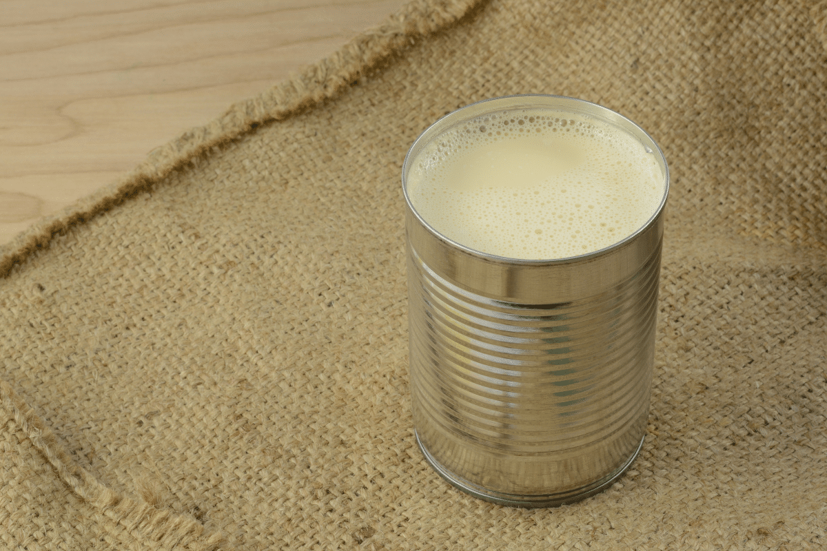 Evaporated milk in a can on a burlap sack.