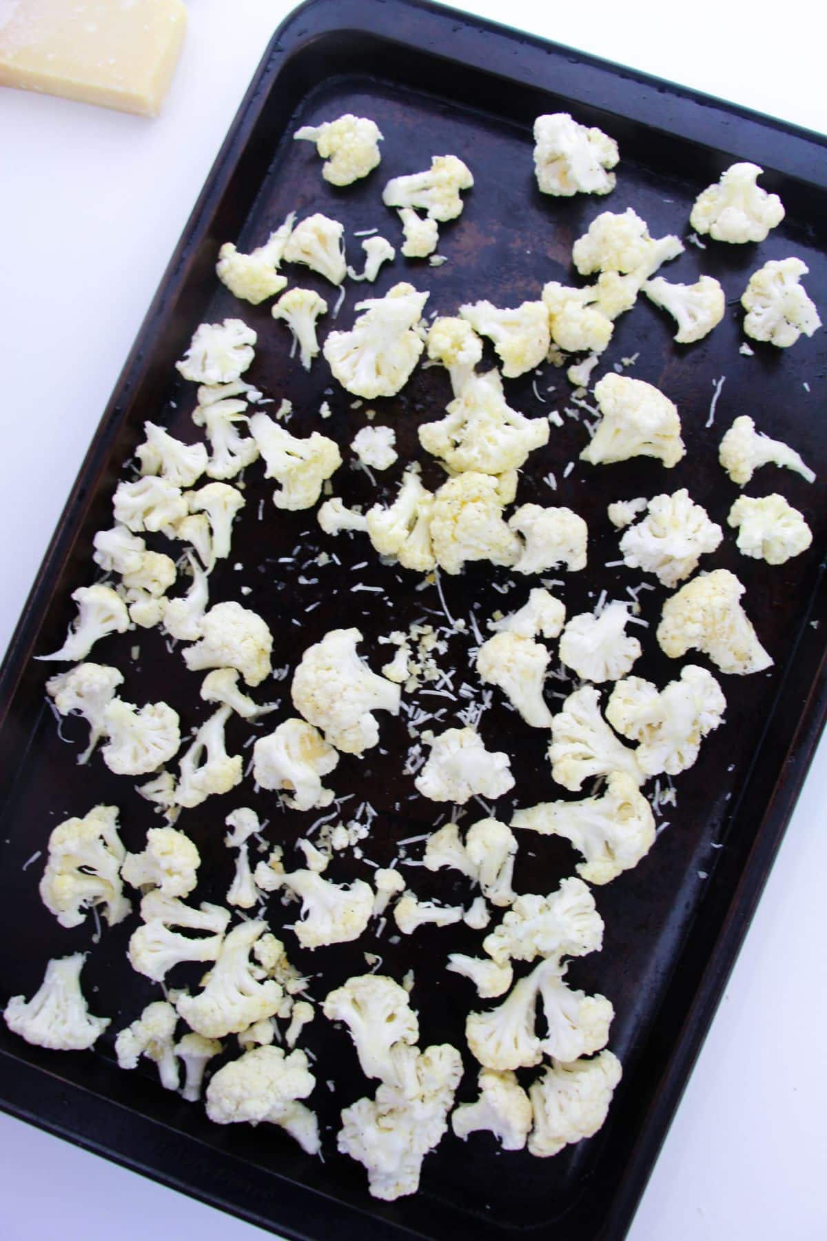 Cauliflower with cheese on a baking sheet.