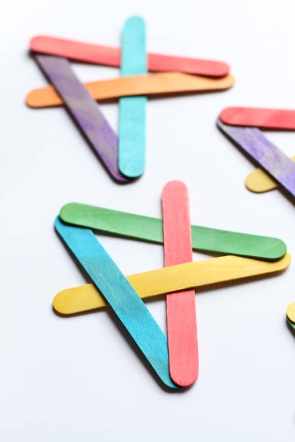 A group of colorful popsicle sticks used for educational activities with kids on a white surface.