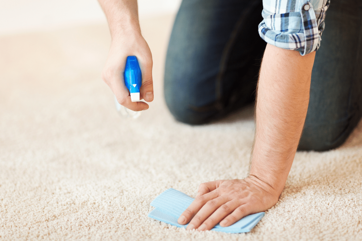 A man removing candle wax from carpet.