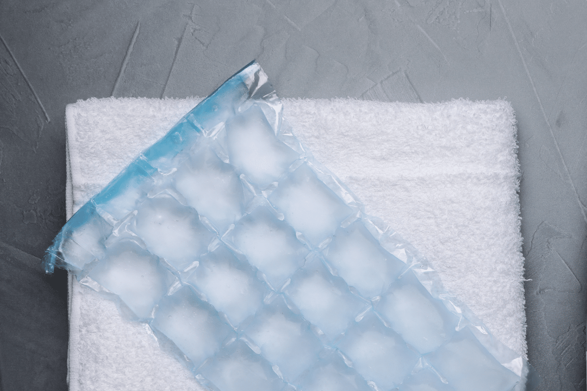 White towel and ice pack on a gray background.