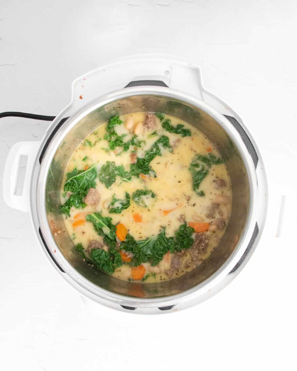 A bean soup with kale and sausage in an instant pot.
