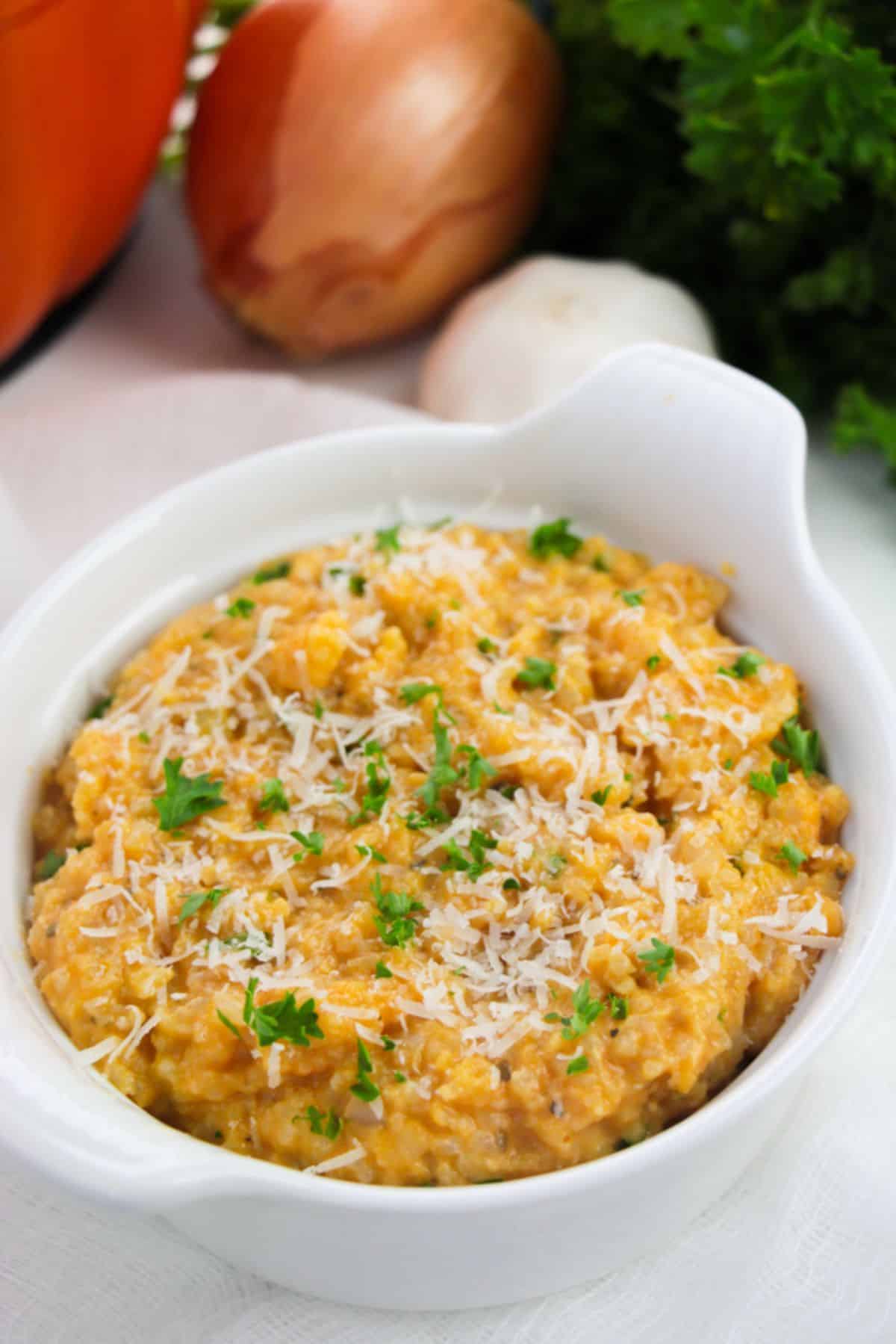 Pumpkin Risotto in a white bowl, garnished with parsley.