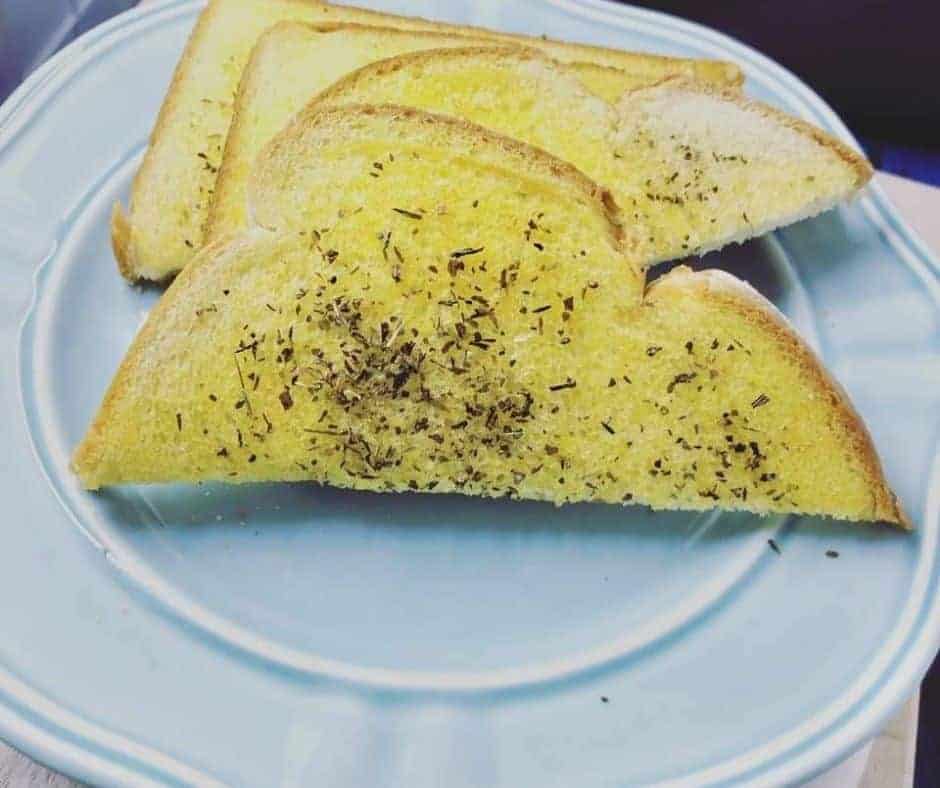 A piece of toast on a blue plate.
