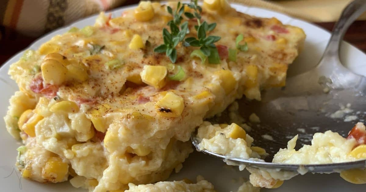 Corn casserole on a plate with a spoon.