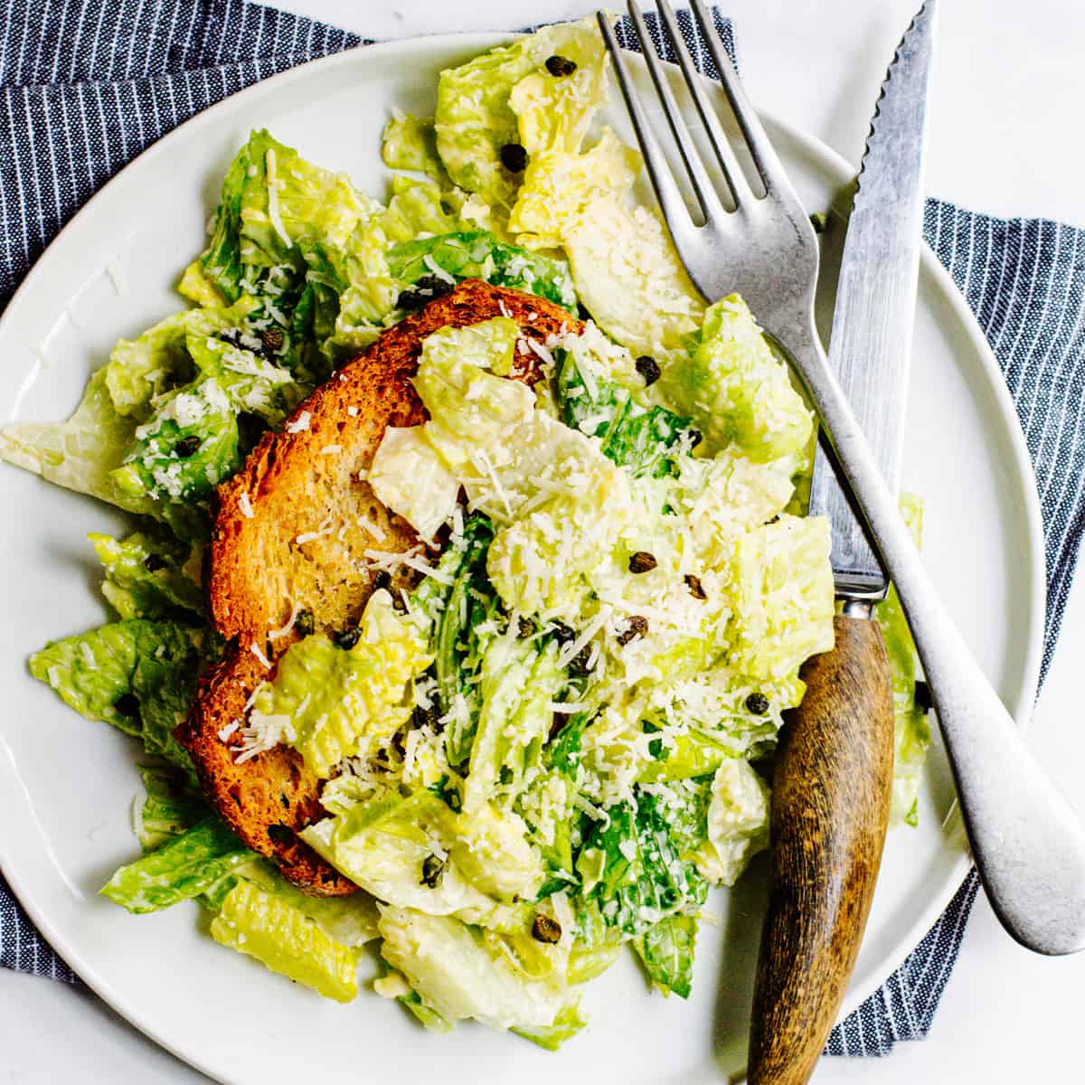 A plate of caesar salad with croutons and parmesan.