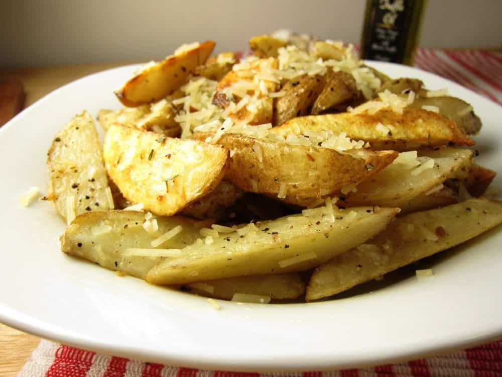 A plate of french fries with parmesan cheese on it.